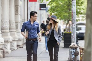 Business People Talking While Walking On Sidewalk In City