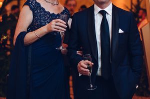 A couple with champagne flutes wearing formal evening wear at a formal event party celebration